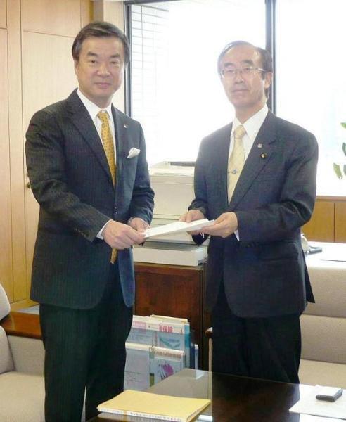 画像：手交式の様子（写真左：松沢緊急雇用対策本部長　写真右：渡辺厚生労働副大臣）