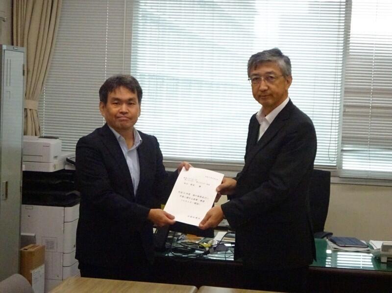 松山省エネルギー・新エネルギー部長(左)へ要望書を手渡す西原エネルギー政策特別委員会委員長代理(右)
